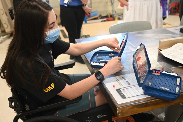 U.S. Air Force Airman 1st Class Lauren Arduser, 311th Training Squadron Russian language analyst, pushes a peg into the map, marking her shot, which missed her opponent’s battleship, at the St. Louis VA Healthcare System-Jefferson Barracks, Missouri, August 17, 2022. Arduser suffered a car accident in March, but her language skills and cognitive ability were unaffected. (U.S. Air Force photo by Senior Airman Abbey Rieves)