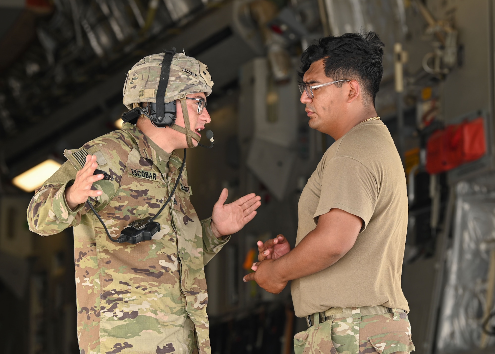 A U.S. Army Soldier debriefs another Soldier before uploading a High Mobility Artillery Rocket System onto U.S. Air Force C-17 Globemaster III assigned to Dover Air Force Base, Delaware, during Exercise GOLDEN BEE at Andersen Air Force Base, Guam, Sept. 26, 2022. Exercise GOLDEN BEE is a joint readiness exercise designed to provide training integration and rehearse strategic and operational objectives in support of Agile Combat Employment initiatives in the Indo-Pacific area of responsibility. (U.S. Air Force photo by Staff Sgt. Aubree Owens)