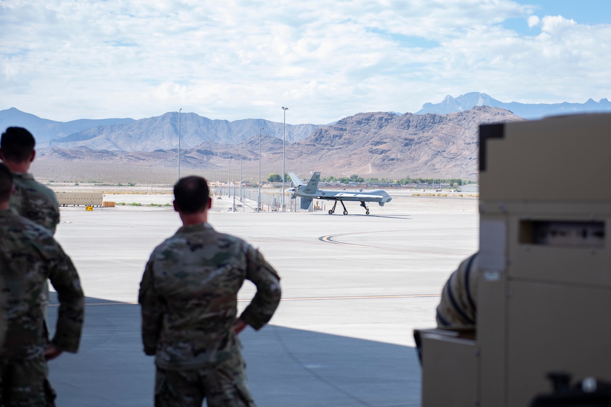 Senior Airman Jacob Allen and Staff Sgt. Matthew Sarcinelli from the 432d Aircraft Maintenance Squadron conduct launch procedures on the flightline for the Portable Aircraft Control Station MQ-9 Reaper Operational Test on July. 12, 2022, at Creech Air Force Base, Nevada. The PACS allows ground personnel to fully generate an aircraft without a line-of-sight Launch and Recovery Cockpit. (U.S. Air Force photo by Mr. Robert Brooks)