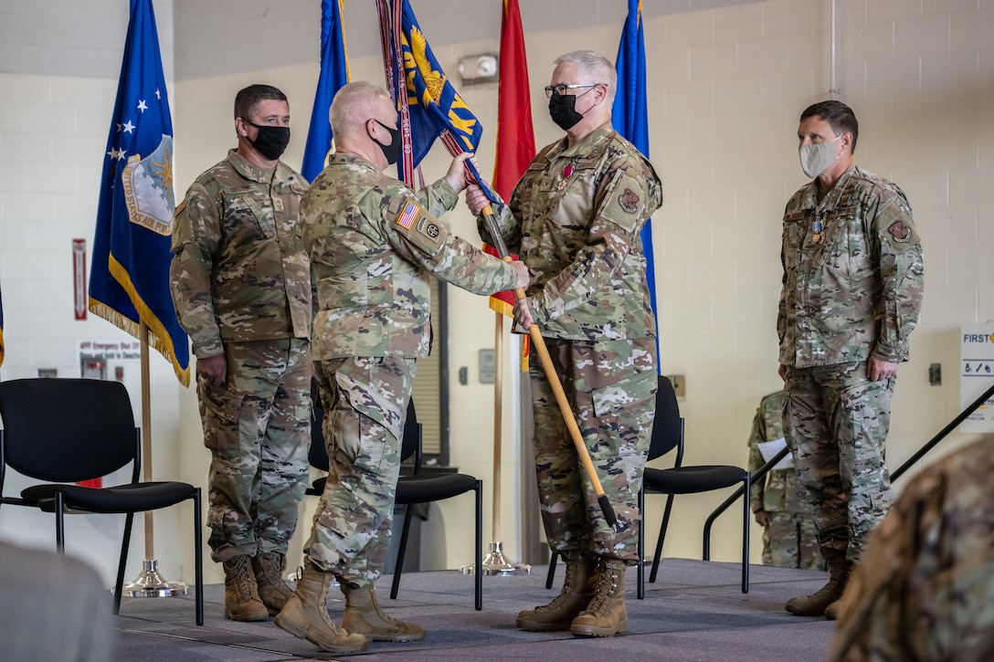 Brig. Gen. David J. Mounkes, center right, accepts the guidon of Headquarters, Kentucky Air National Guard, from Army Maj. Gen. Haldane B. Lamberton, center left, adjutant general of the Commonwealth of Kentucky, during a change-of-command ceremony at the Kentucky Air National Guard Base in Louisville, Ky., Aug. 13, 2022. Mounkes assumed command of the Kentucky Air Guard at the event, taking on the role of assistant adjutant general for Air from Brig. Gen. Jeffrey L. Wilkinson, far right, who is retiring. (U.S. Air National Guard photo by Dale Greer)