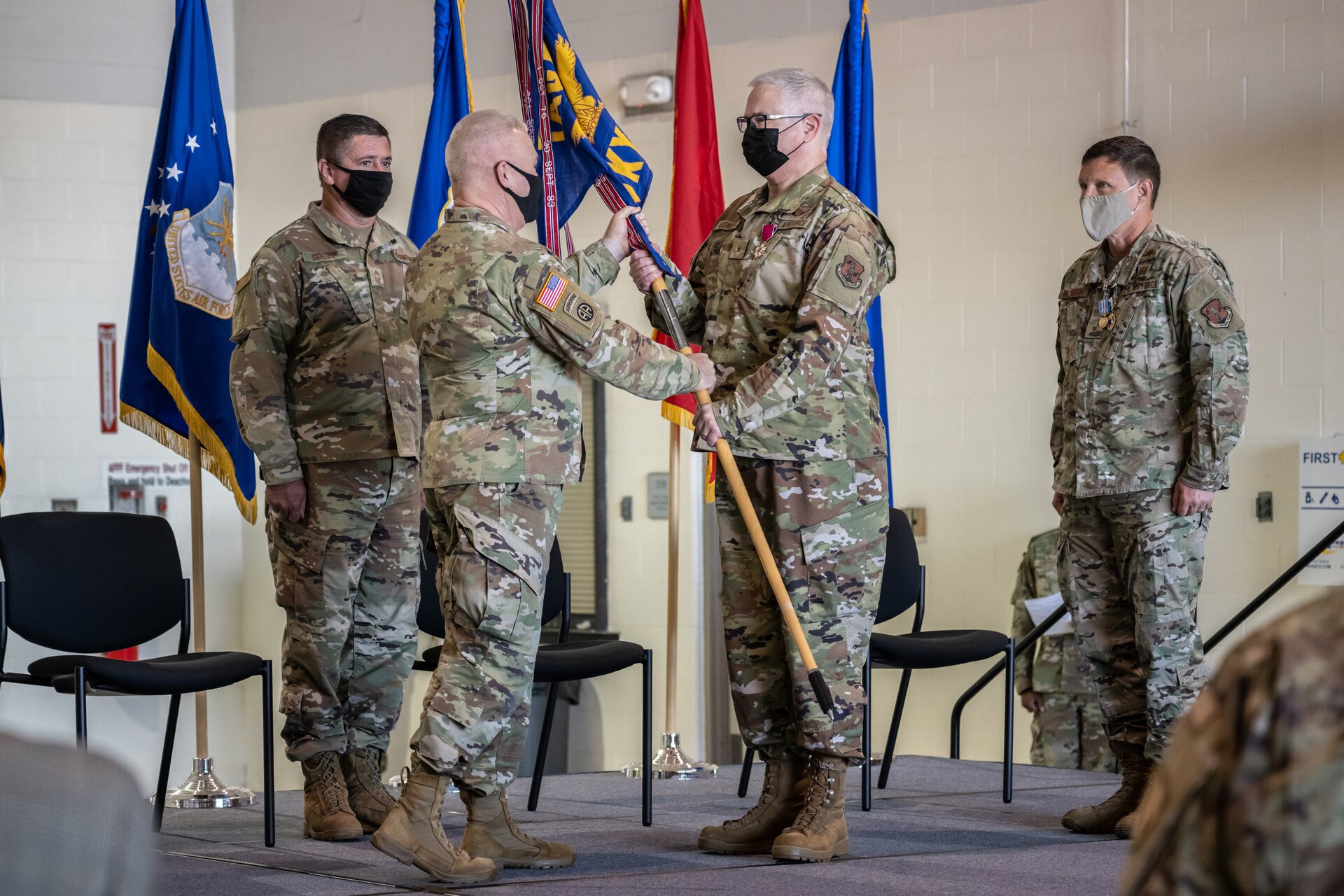 Brig. Gen. David J. Mounkes, center right, accepts the guidon of Headquarters, Kentucky Air National Guard, from Army Maj. Gen. Haldane B. Lamberton, center left, adjutant general of the Commonwealth of Kentucky, during a change-of-command ceremony at the Kentucky Air National Guard Base in Louisville, Ky., Aug. 13, 2022. Mounkes assumed command of the Kentucky Air Guard at the event, taking on the role of assistant adjutant general for Air from Brig. Gen. Jeffrey L. Wilkinson, far right, who is retiring. (U.S. Air National Guard photo by Dale Greer)