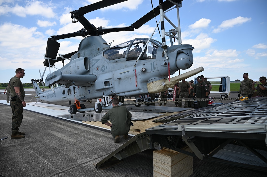 Reserve Citizen Airmen with the 68th Airlift Squadron and Marines with the Marine Light Attack Helicopter Squadron – 773, Det. Alpha guide a Bell AH-1Z Viper helicopter onto a C-5M Super Galaxy aircraft at Naval Air Station Joint Reserve Base New Orleans, Louisiana, Sept. 13, 2022. This was the first time the Marines from the HMLA-733 participated in the NATO days air show. (U.S. Air Force photo by Staff Sgt. Monet Villacorte)
