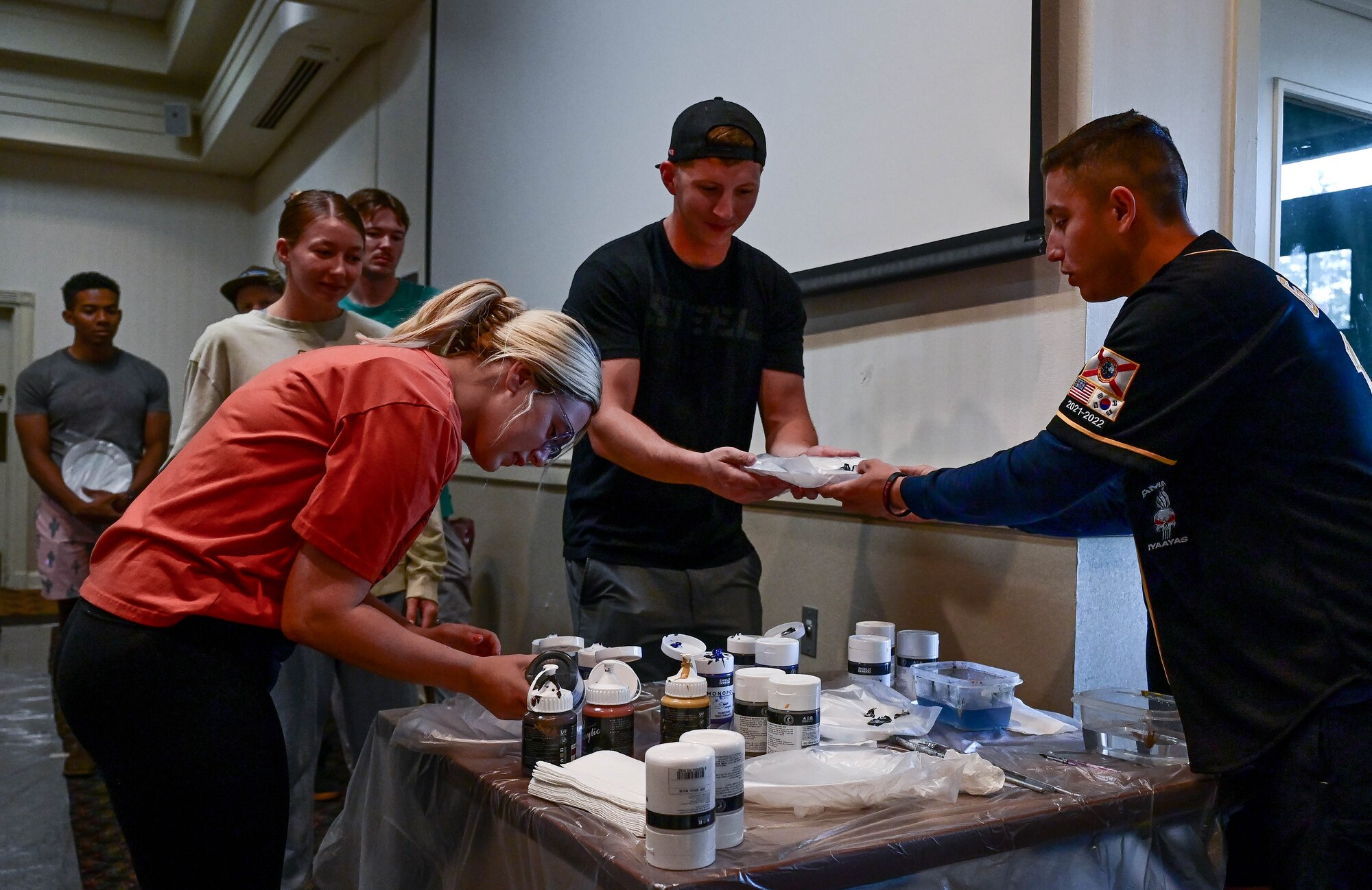 Students collect paint on their palettes.