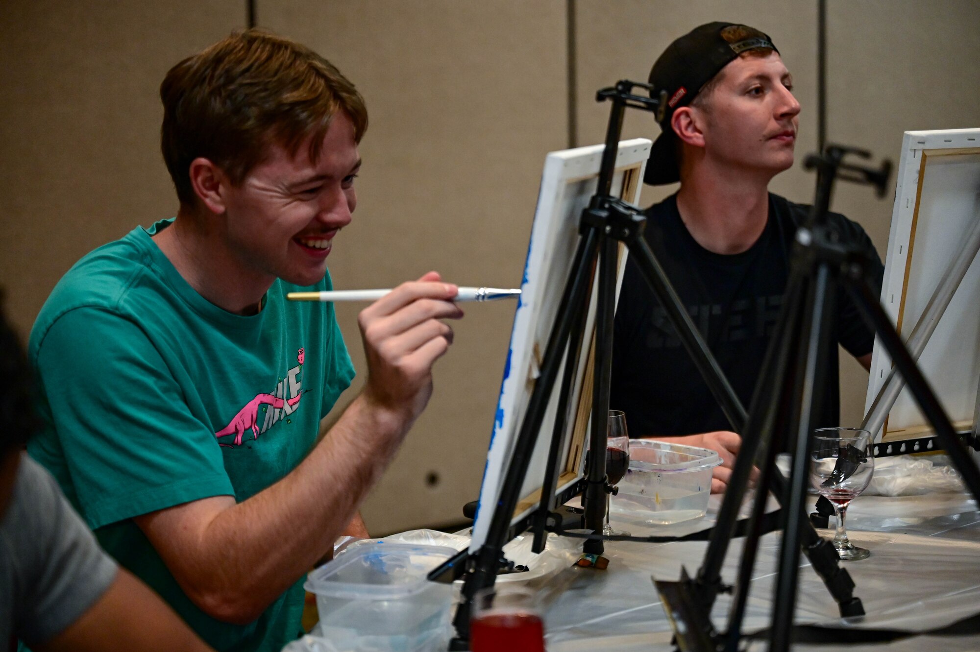 Man smiles while painting.