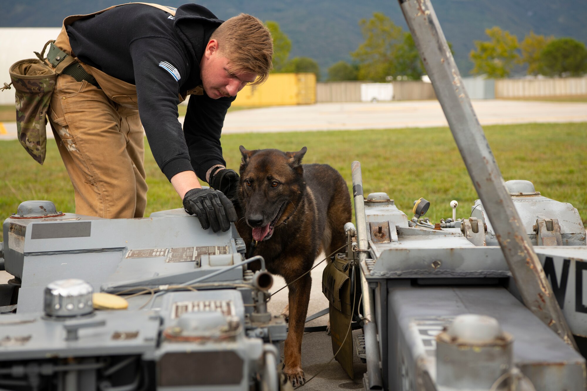 Kay, 31st Security Forces military working dog, and Senior Airman Ian Moran, 31st Security Forces military working dog handler, search for simulated explosives during a training at Aviano Air Base, Italy, Sept. 28, 2022. MWDs and their handlers act as a single unit and deploy on missions together. (U.S. Air Force photo by Airman 1st Class Thomas Calopedis)