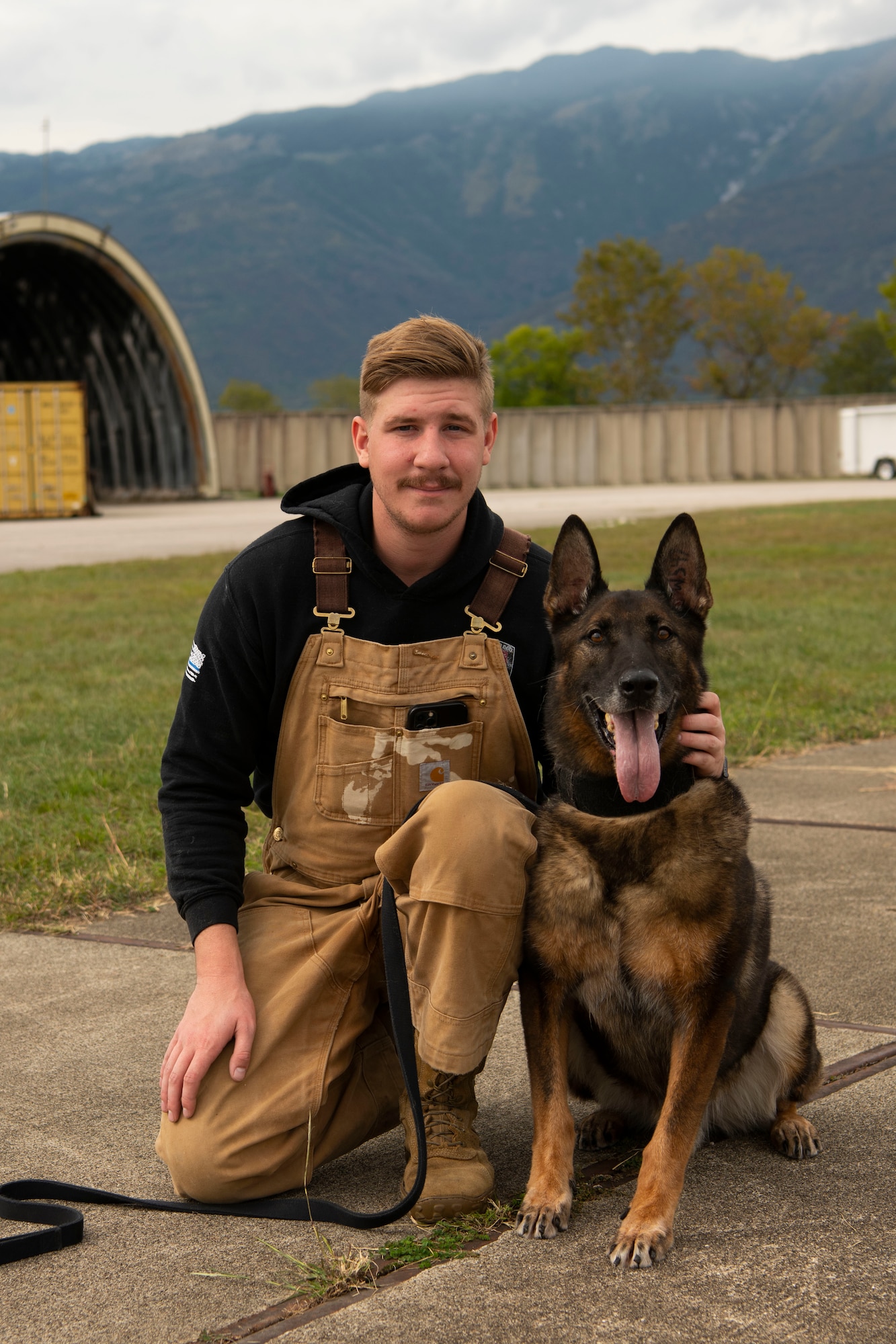Kay, 31st Security Forces military working dog, and Senior Airman Ian Moran, 31st Security Forces military working dog handler, pose for a photo during a training at Aviano Air Base, Italy, Sept. 28, 2022. MWDs and their handlers must go through rapport training early on to build trust and familiarity, enabling them to perform training and later detection and patrol duties. (U.S. Air Force photo by Airman 1st Class Thomas Calopedis)