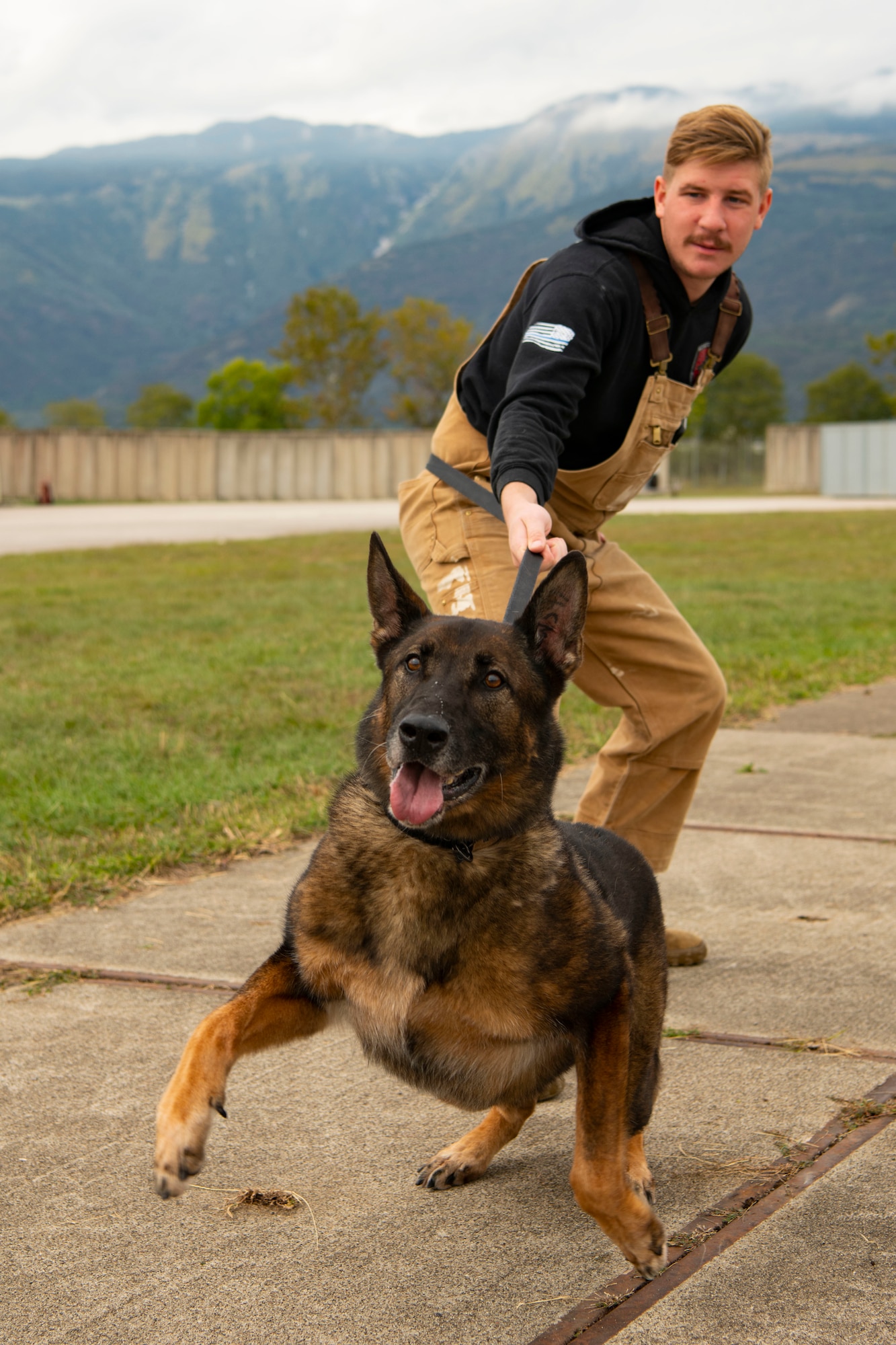 Kay, 31st Security Forces military working dog, and Senior Airman Ian Moran, 31st Security Forces military working dog handler, pose for a photo during a training at Aviano Air Base, Italy, Sept. 28, 2022. MWDs and their handlers must go through rapport training early on to build trust and familiarity, enabling them to perform training and later detection and patrol duties. (U.S. Air Force photo by Airman 1st Class Thomas Calopedis)