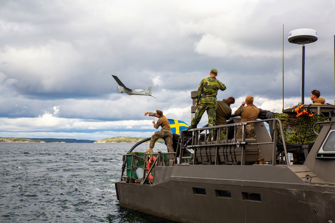 A Marine hurls a drone off a boat and into flight.