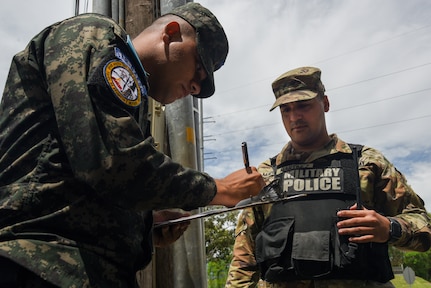 Sgt. Eduardo Martinez, a military police officer with the Puerto Rico National Guard's 225th Military Police Company Law Enforcement Detachment, works with his Honduran Armed Forces counterpart to sign visitors into Soto Cano Air Base in Honduras Sept. 14, 2022. The 225th military police have partnered with Honduran forces at Soto Cano Air Base for more than 10 years.