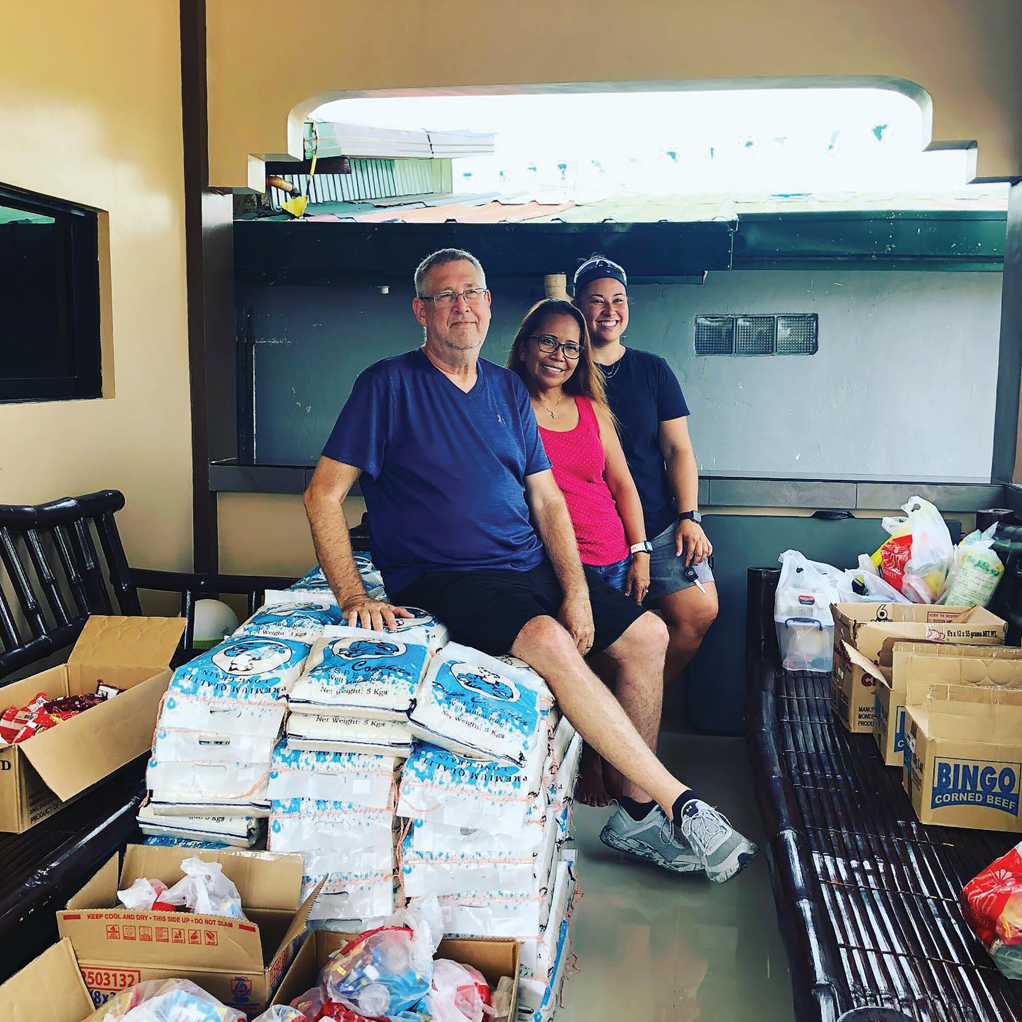 Staff Sgt. Michelle Logan, 445th Aerospace Medicine Squadron, and her parents, John and Judy Logan, pose with food purchased for donations in the Philippines in August 2022. John was stationed at Clark Air Base, Philippines, as a jet engine mechanic in the 80s.