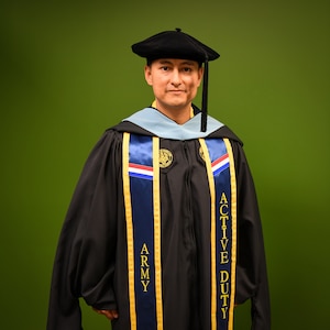 man in u.s. army uniform wearing a graduation gown.