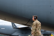An Airman stands next to an aircraft.