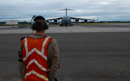 An Airman marshalls an aircraft.