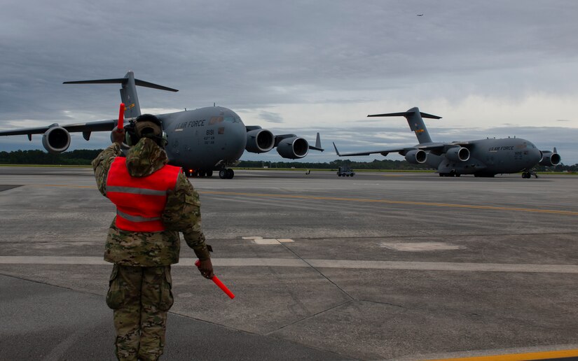 An Airman marshalls an aircraft.