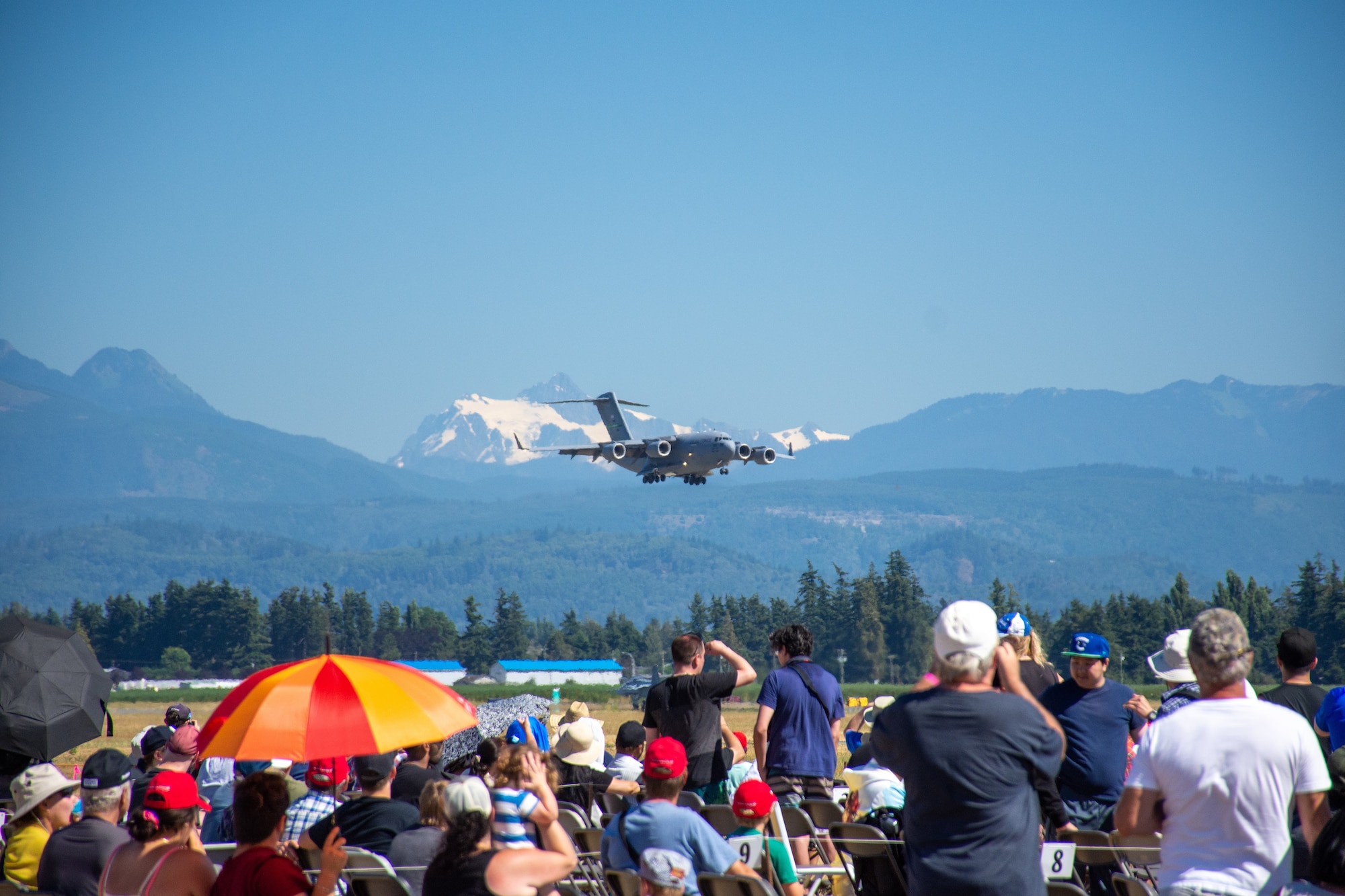 Aircraft flies before a crowd of people.