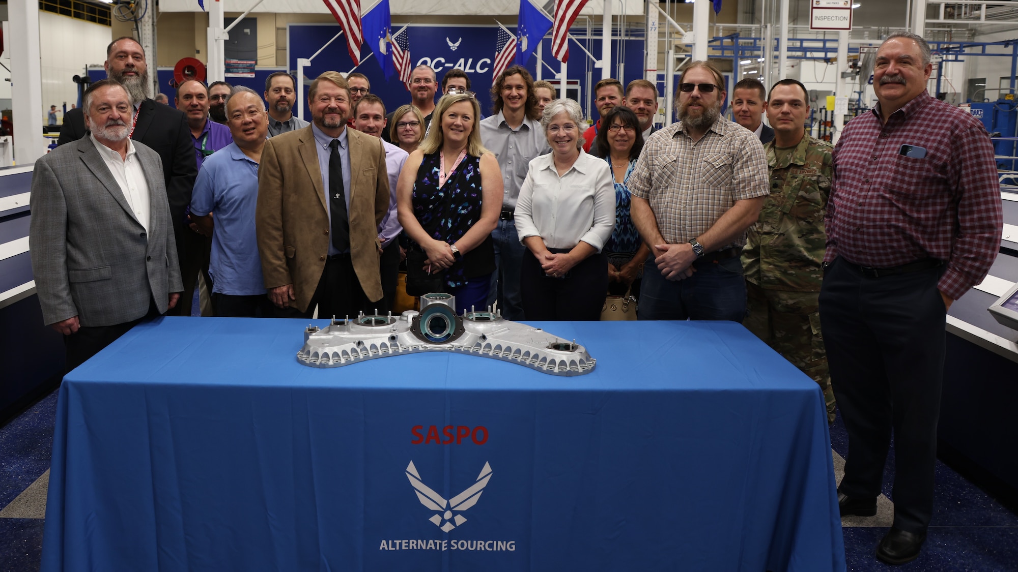 People posing for group photo behind table