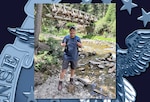 Photo of a man in hiking gear smiling while standing outside.