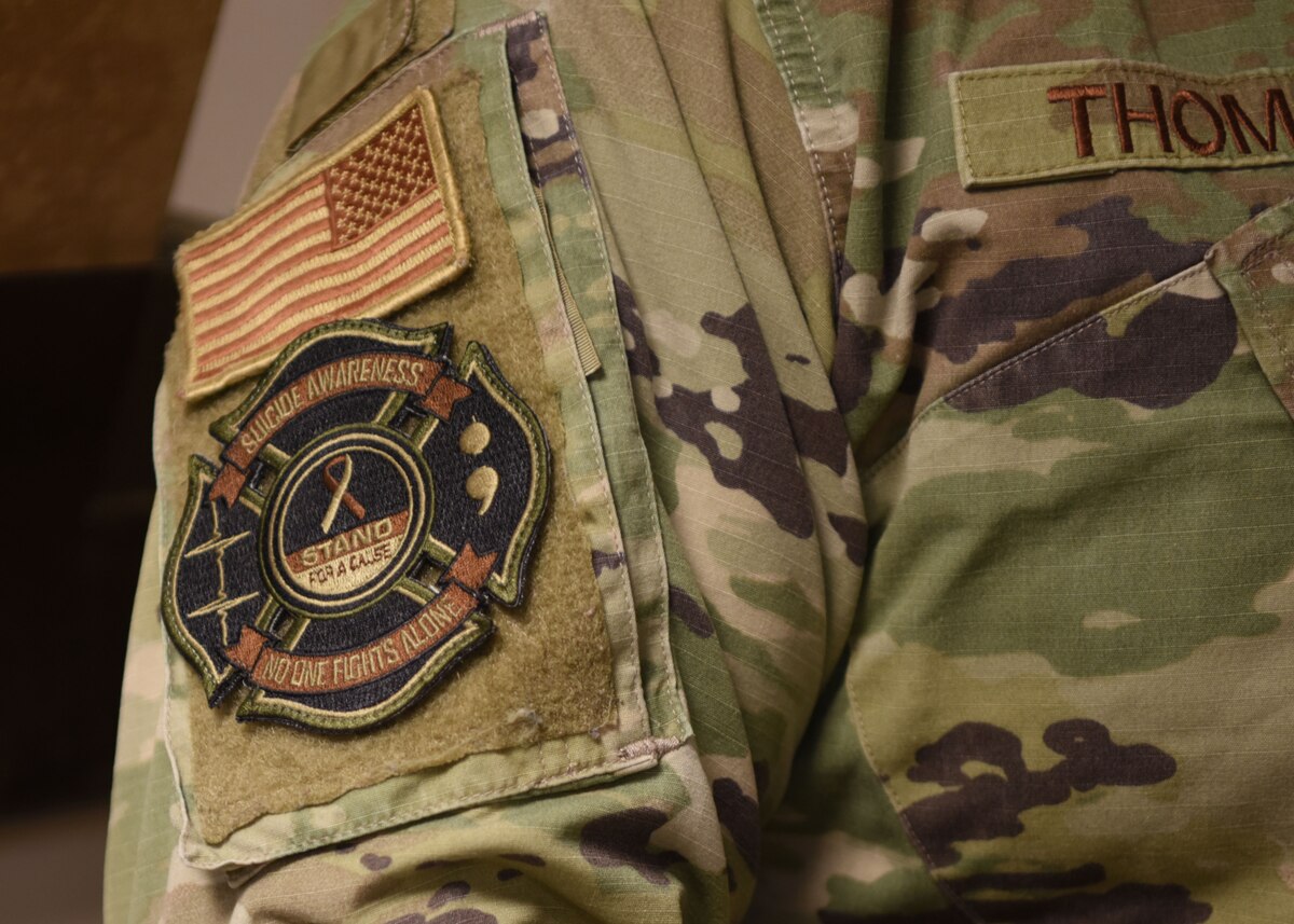 An airman displays his suicide awareness patch at Goodfellow Air Force Base, Texas, Sept. 8, 2022. The goal of the patch is to increase suicide awareness and spark conversations among military members. (U.S. Air Force photo by Senior Airman Ethan Sherwood)