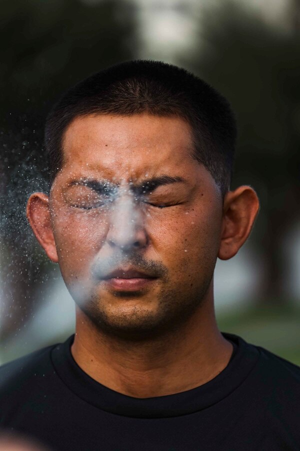 A Japanese Security Guard with Provost Marshal’s Office, Headquarters and Support Battalion, Marine Corps Installations Pacific, gets sprayed during an oleoresin capsicum spray response training on Camp Foster, Okinawa, Japan, Sep. 16, 2022.  During the Marine-led training, JSGs navigated through an obstacle course while experiencing the effects of OC spray, also known as pepper spray. The training consists of tactics to subdue and arrest a subject and ensures law enforcement personnel understand the effects of the spray. (U.S. Marine Corps photo by Lance Cpl. Jonathan Beauchamp)