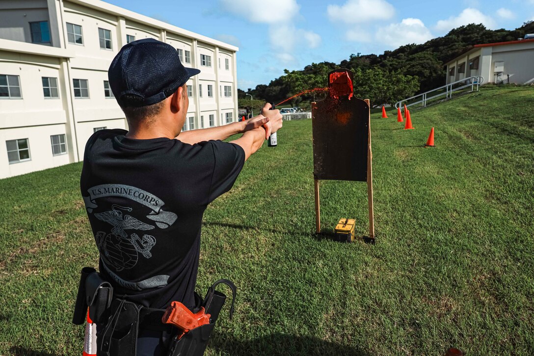 A Japanese Security Guard with Provost Marshal’s Office, Headquarters and Support Battalion, Marine Corps Installations Pacific, sprays oleoresin capsicum at a target during an OC spray response training on Camp Foster, Okinawa, Japan, Sep. 16, 2022.  During the Marine-led training, JSGs navigated through an obstacle course while experiencing the effects of OC spray, also known as pepper spray. The training consists of tactics to subdue and arrest a subject and ensures law enforcement personnel understand the effects of the spray. (U.S. Marine Corps photo by Lance Cpl. Jonathan Beauchamp)