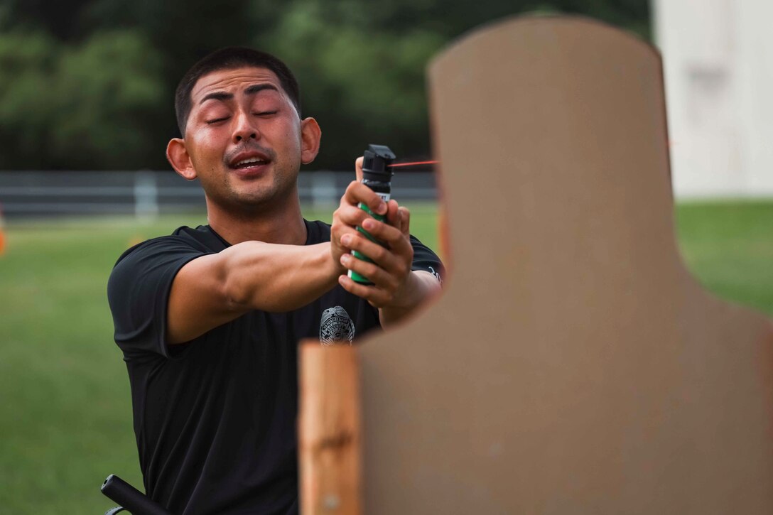 A Japanese Security Guard with Provost Marshal’s Office, Headquarters and Support Battalion, Marine Corps Installations Pacific, sprays oleoresin capsicum at a target during an OC spray response training on Camp Foster, Okinawa, Japan, Sep. 16, 2022.  During the Marine-led training, JSGs navigated through an obstacle course while experiencing the effects of OC spray, also known as pepper spray. The training consists of tactics to subdue and arrest a subject and ensures law enforcement personnel understand the effects of the spray. (U.S. Marine Corps photo by Lance Cpl. Jonathan Beauchamp)