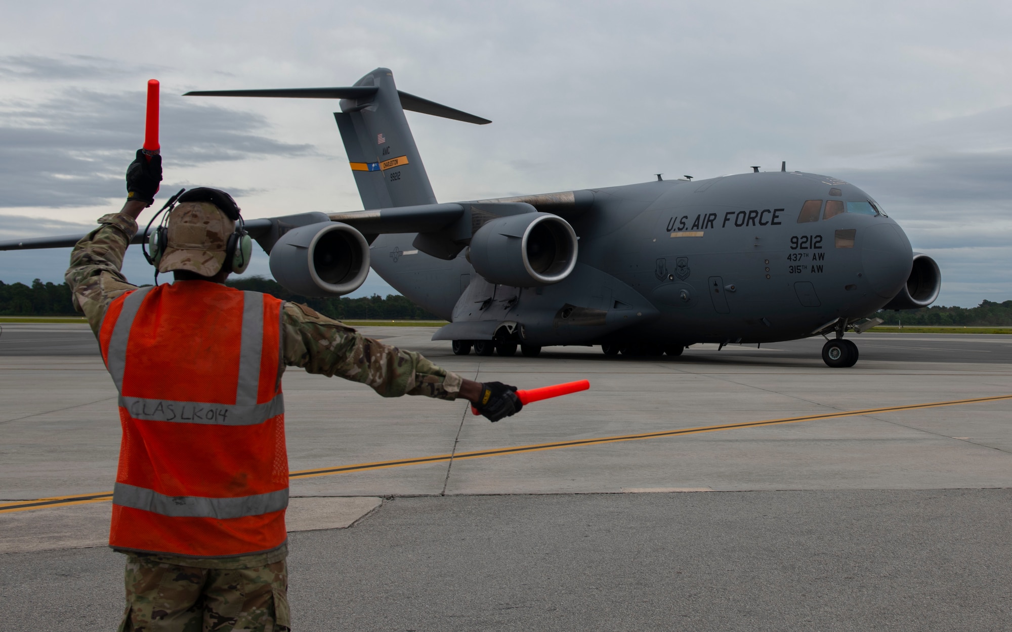 An Airman marshals a jet.