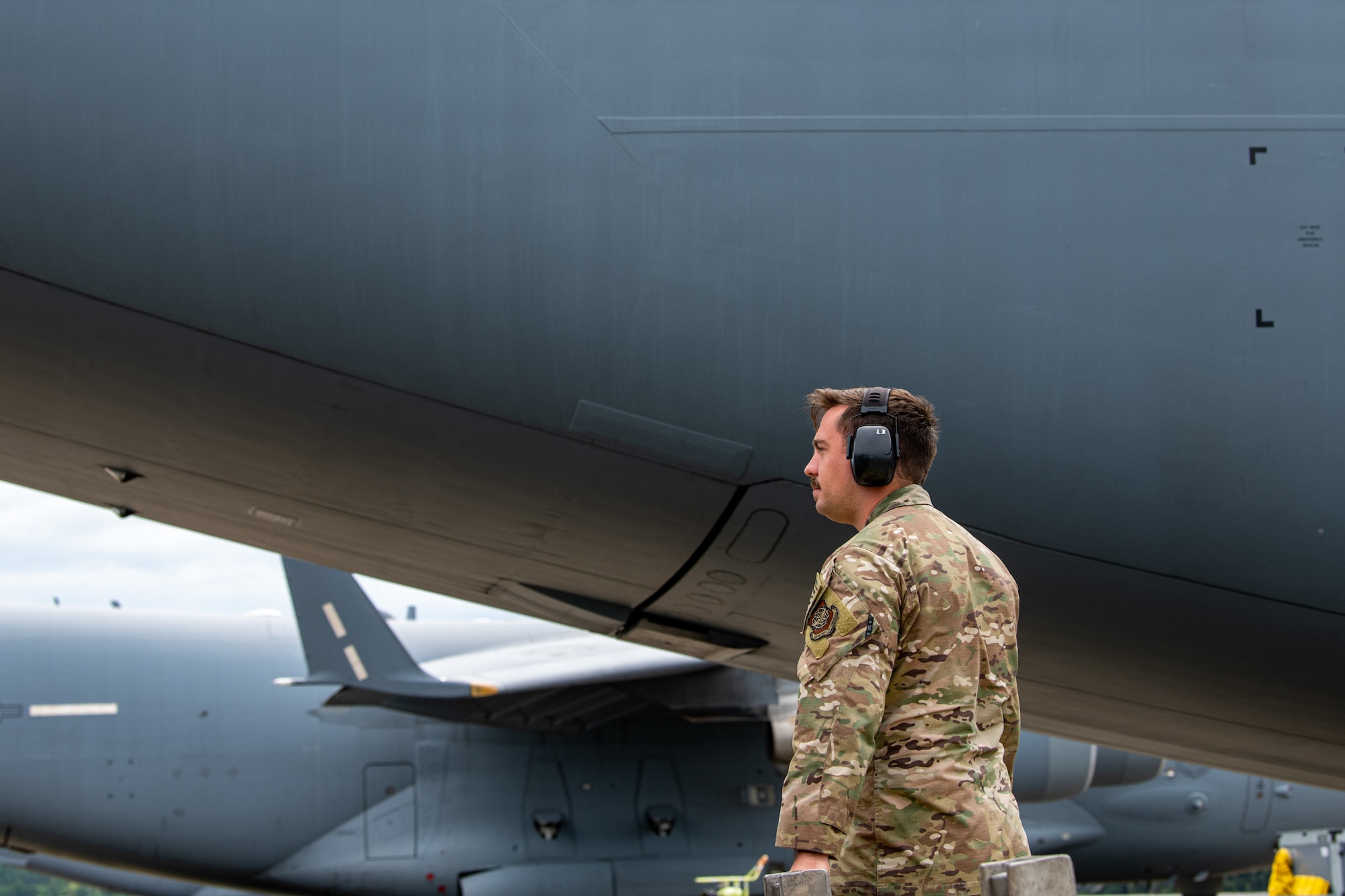 An Airman stands next to an aircraft.