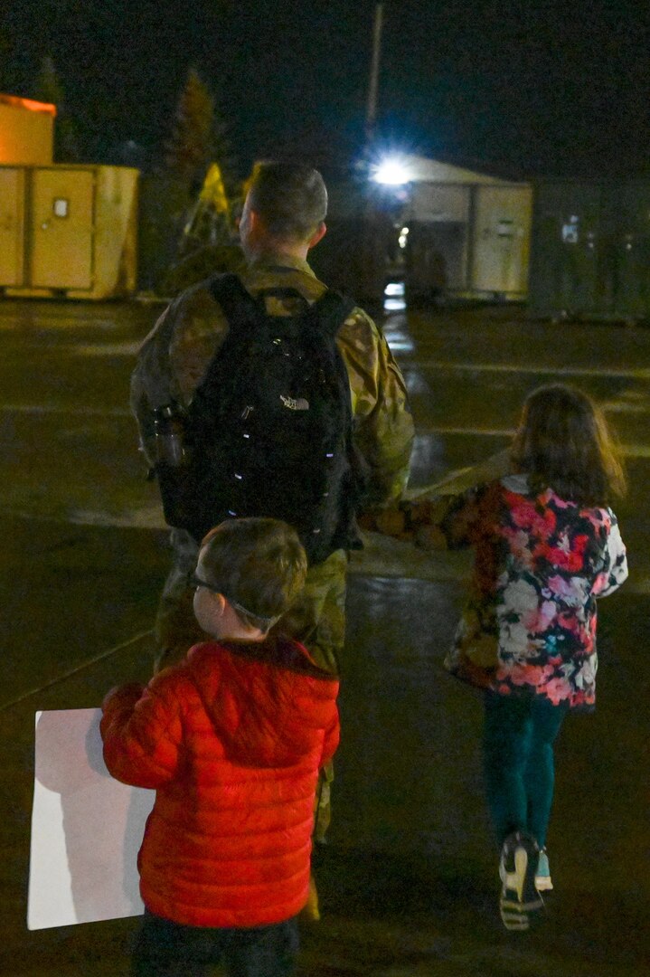 An Airman from the 23rd Expeditionary Bomb Squadron greets his children after returning from a Bomber Task Force deployment at Minot Air Force Base, North Dakota, Sept. 24, 2022. The 23rd BS personnel were deployed to RAF Fairford, England to integrate with NATO allies and partners. (U.S. Air Force photo by Senior Airman Zachary Wright)
