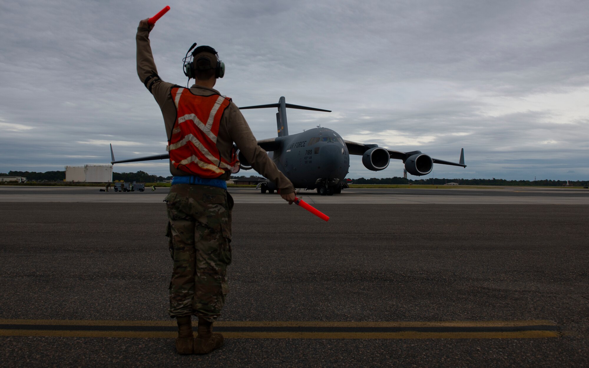 An Airman marshalls an aircraft.