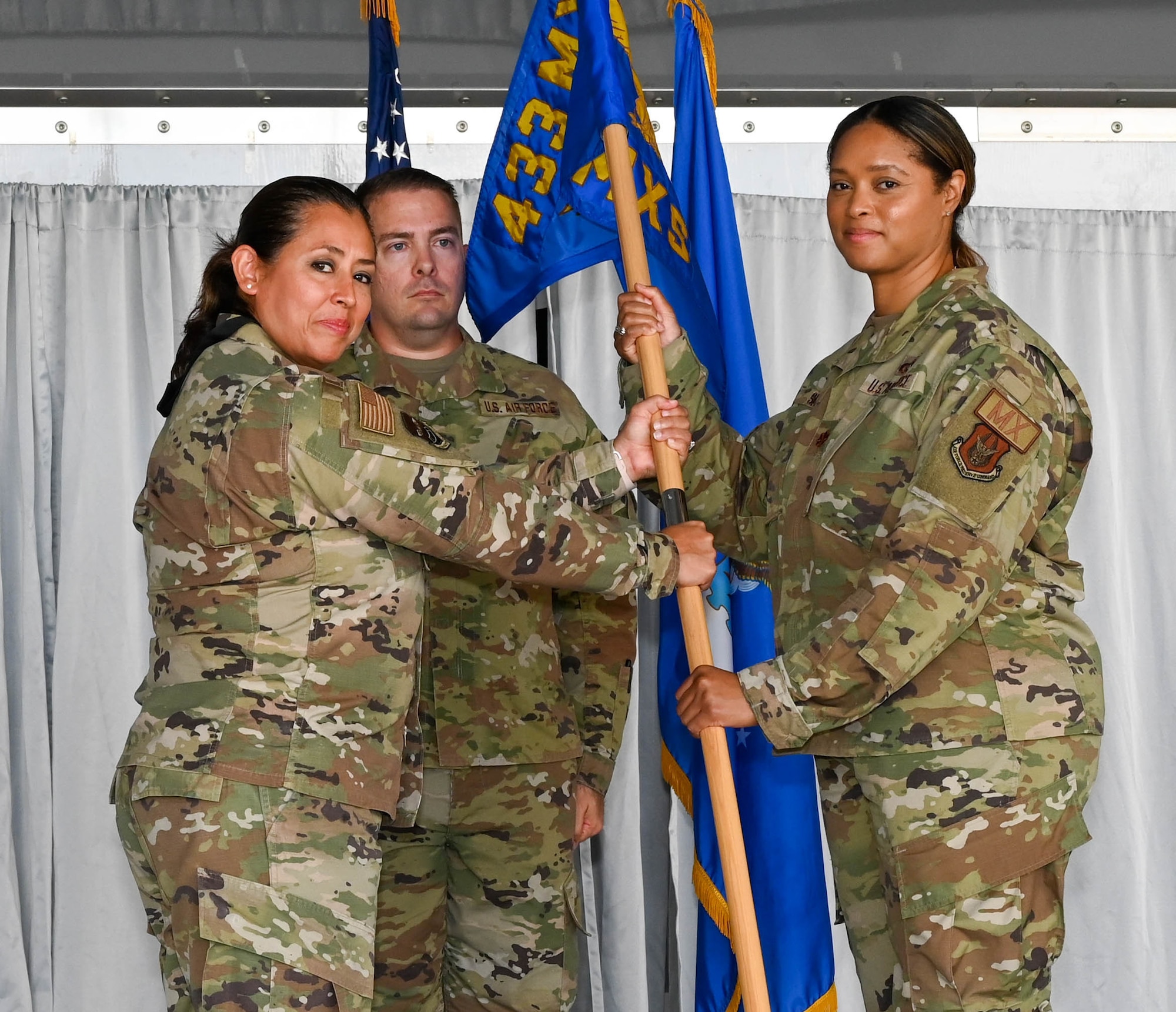 Lt. Col. Carla Martinez, 433rd Maintenance Group commander (left), presents the 433rd Maintenance Squadron guidon to Maj. Yolanda Seals during the 433rd MXS change of command ceremony at Joint Base San Antonio-Lackland, Texas, Sept. 10, 2022. Seals was previously the executive officer to the 340th Flying Training Group commander at Joint Base San Antonio-Randolph, Texas. (U.S. Air Force photo by Airman 1st Class Mark Colmenares)