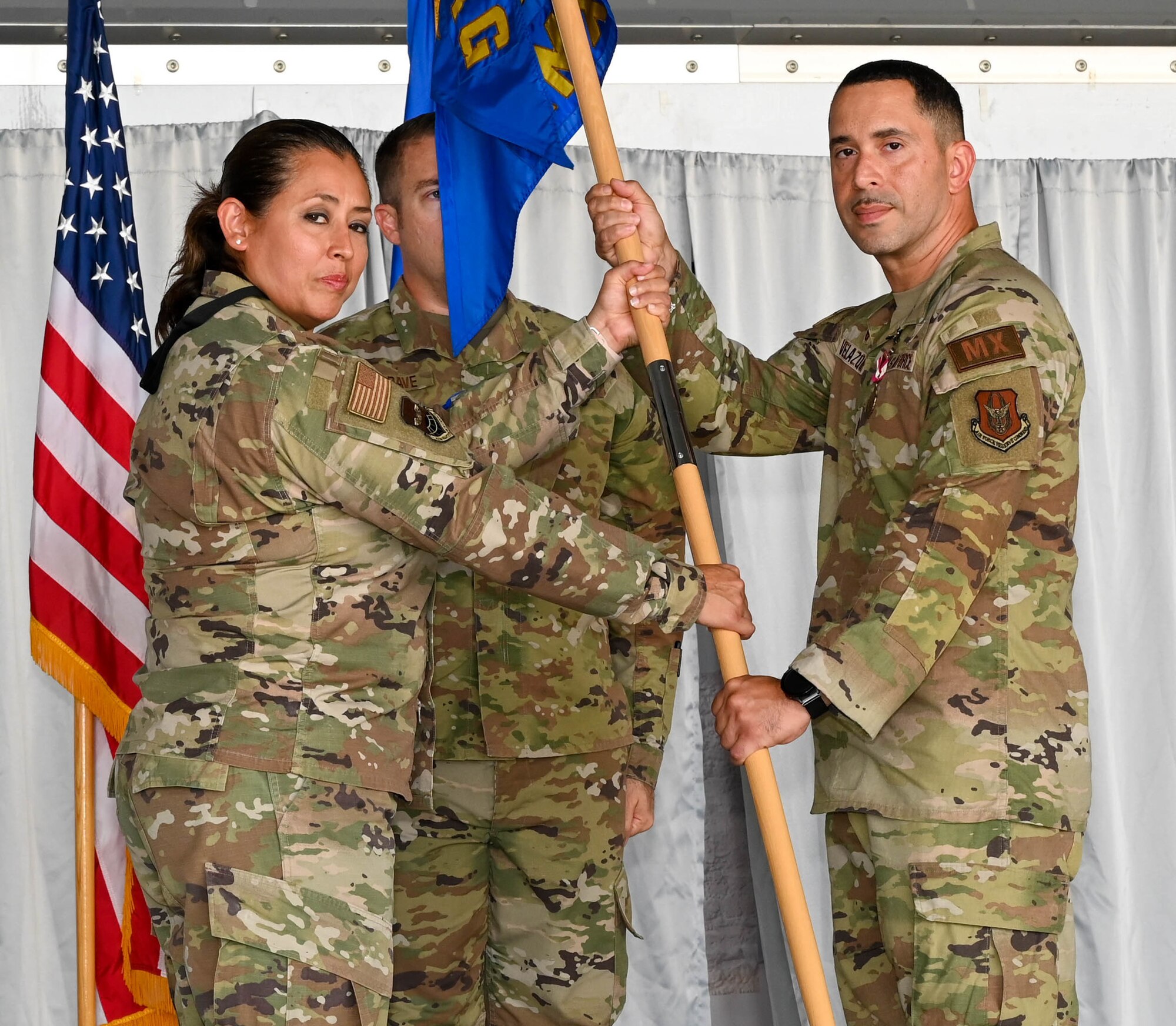 Lt. Col. Carla Martinez, 433rd Maintenance Group commander, presents the 433rd Aircraft Maintenance Squadron guidon to Maj. Nicholas Velazquez Jr. during the 433rd AMXS change of command ceremony at Joint Base San Antonio-Lackland, Texas, Sept. 10, 2022. Velazquez previously served as the 433rd Maintenance Squadron Commander in the 433rd Airlift Wing. (U.S. Air Force photo by Airman 1st Class Mark Colmenares)
