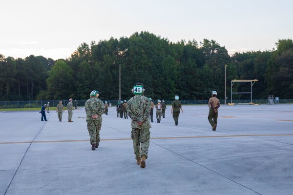 Sailors walking outside on a flightline