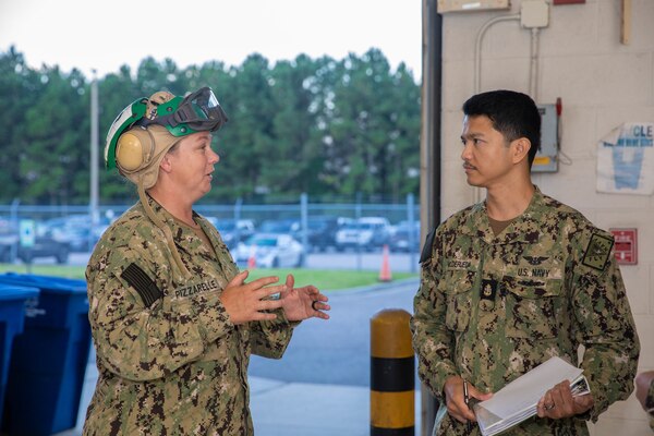 Two Sailors talking to each other by a hangar door