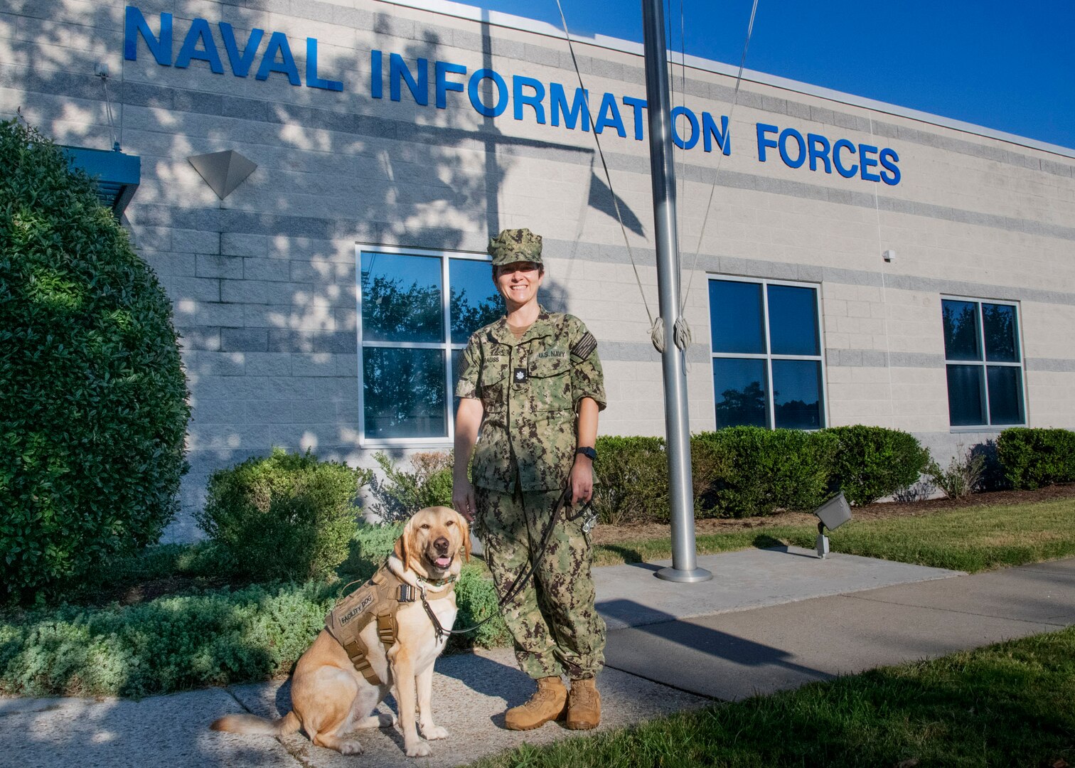 Cmdr. Tracy Krauss, Officer in Charge, Public Health Specialty Leader, and Norfolk-based facility therapy dog, Patty Mac, visited Naval Information Forces and the other two information warfare command on the DoD Suffolk Complex.  Patty Mac works in the waiting room of the Sewells Point Branch Health Clinic where she has the opportunity to alert her handler of patients who are in emotional stress thereby allowing staff to identify ways to help.  (U.S. Navy Photo by Jason Rodman/Released)