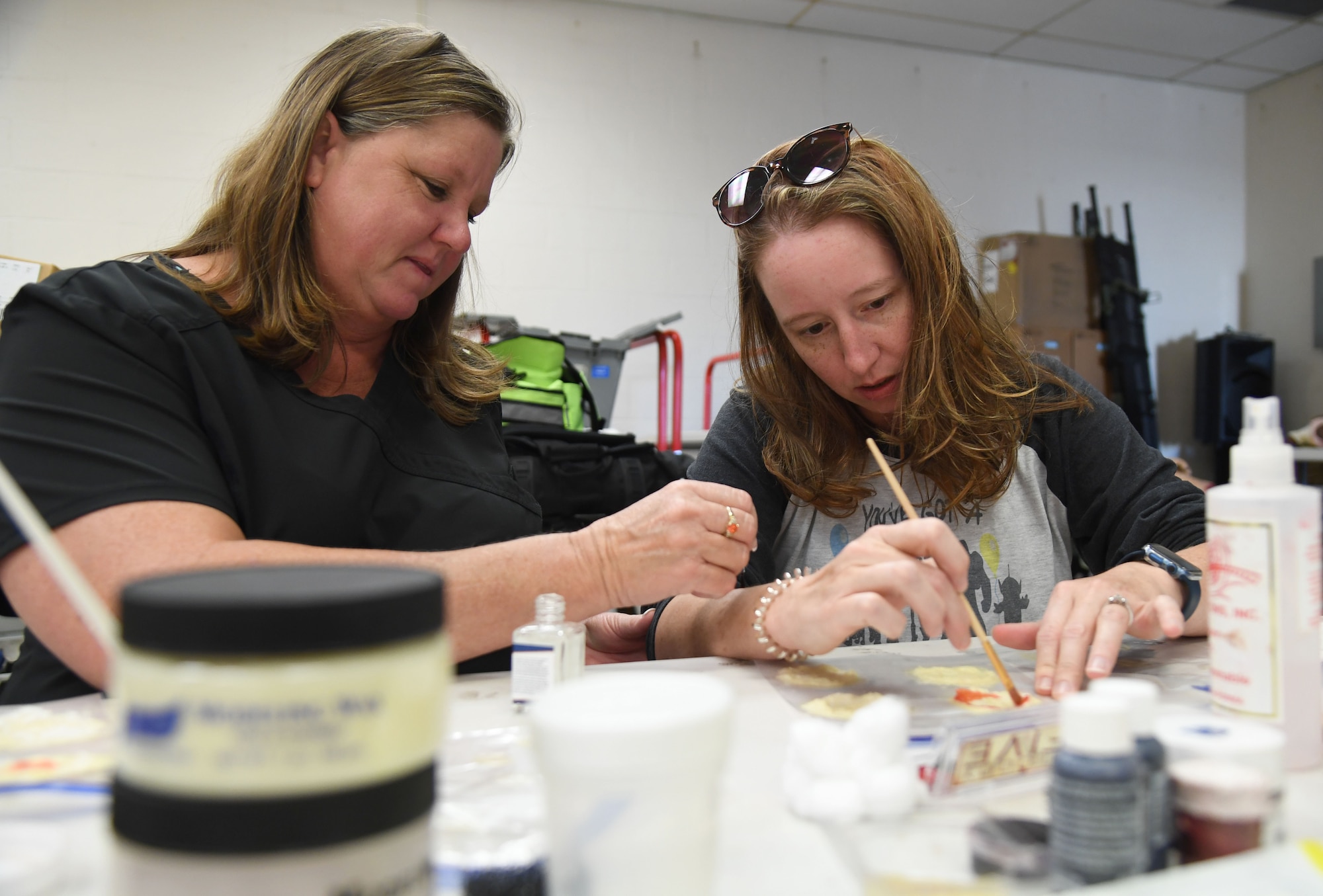 Kim Blackwell, Mississippi State Department of Health emergency planner, and Sarah McCain, Mississippi State Department of Health emergency preparedness nurse, participate in moulage training at Keesler Air Force Base, Mississippi, Sept. 28, 2022. The training was held in preparation for the upcoming mass casualty exercise in October. The purpose of adding moulage to simulated victims is to make the scenario as realistic as possible, so first responders can treat them and react appropriately according to the injuries. (U.S. Air Force photo by Kemberly Groue)