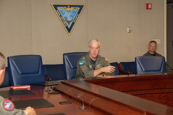 Admiral speaking with Sailors in a conference room