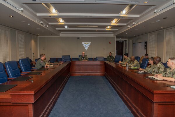 Admiral speaking with Sailors in a conference room