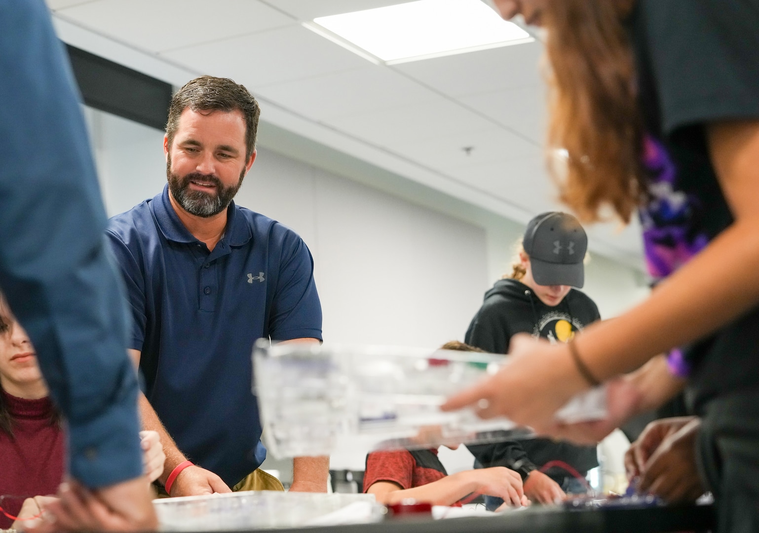 IMAGE: Naval Surface Warfare Center Dahlgren Division (NSWCDD) Director of Academic Engagement, Michael Clark, supervises as Drew Middle School students complete snap circuit board projects during a STEM event for at University of Mary Washington’s (UMW) Seacobeck Hall. NSWCDD partnered with UMW faculty and the UMW College of Education students to host the event. (U.S. Navy Photos/Released)