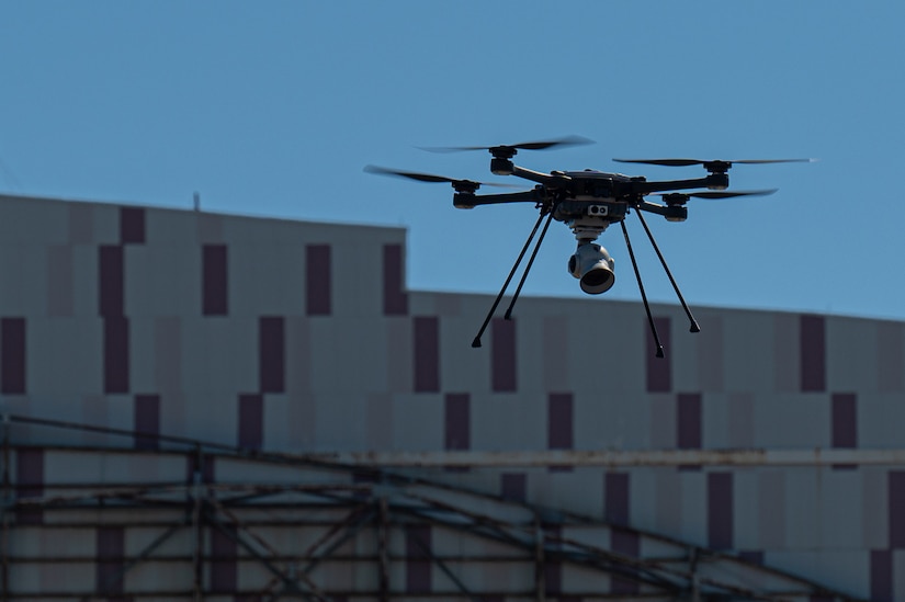 A drone captures imagery from a hangar.