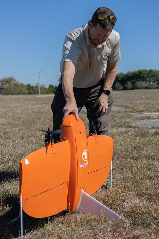 A member from the Air Force Civil Engineering Center Geo-Integration Office sets up a drone for take-off.