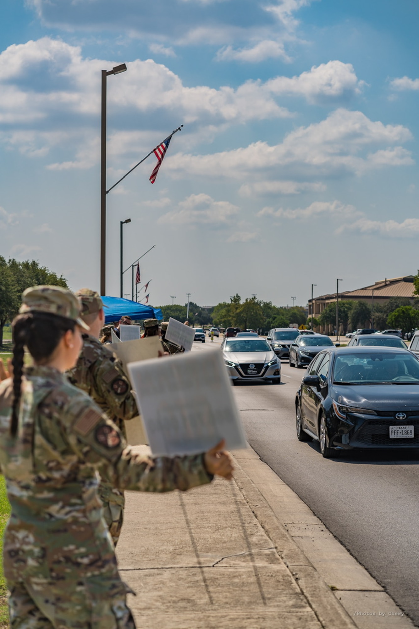 Squadron members hold up motivational signs and greet drivers as they enter the installation Sept. 13.