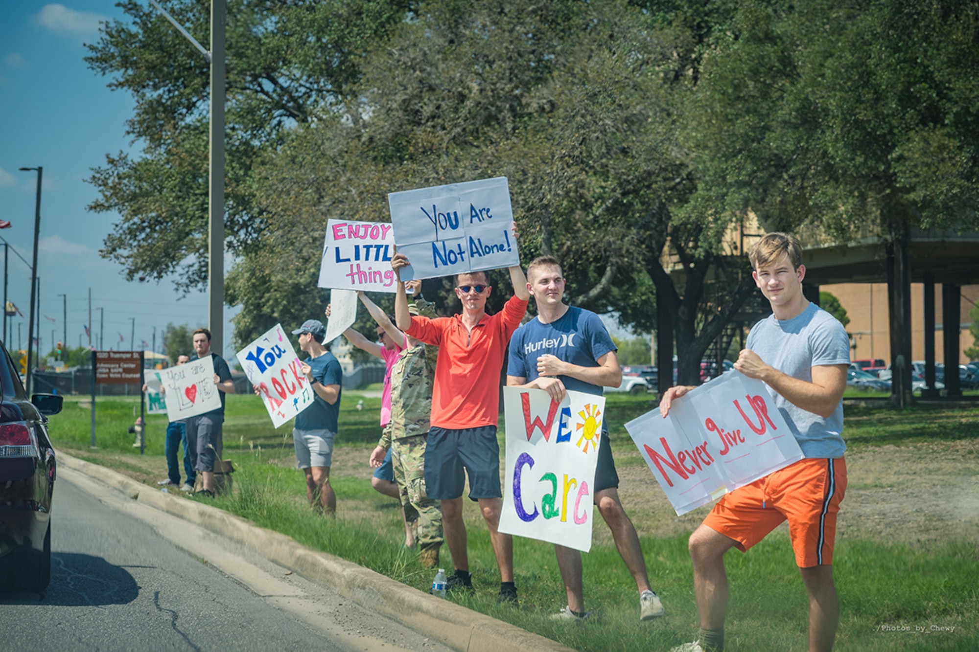 Squadron members hold up motivational signs and greet drivers as they enter the installation Sept. 13.