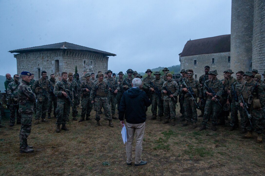 U.S. Marines with 2d Battalion, 8th Marine Regiment, 2d Marine Division, gather around a French guest during Exercise Manticore in France, Sept. 23, 2022. Exercise Manticore is a French Army-led large scale exercise that integrated the Marines into a platoon-sized maneuver element to conduct offensive and defensive operations. (U.S. Marine Corps photo by Lance Cpl. Christopher Doughty)