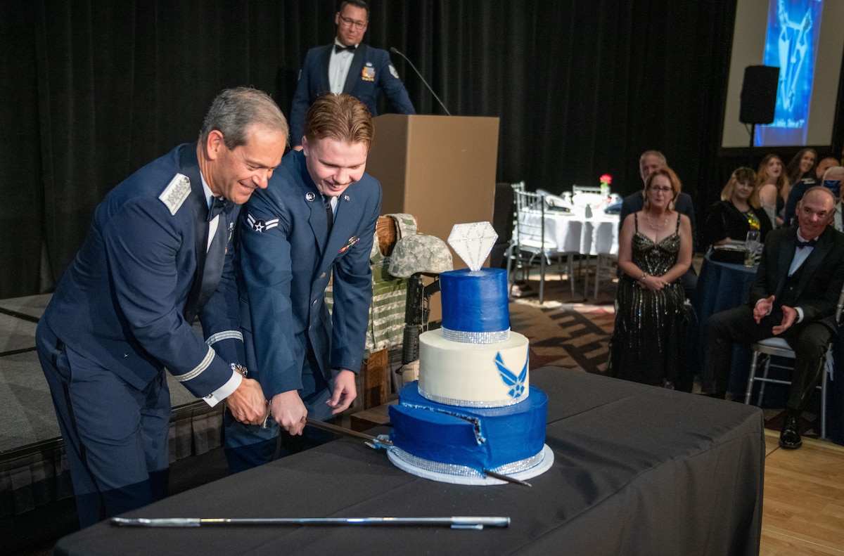 U.S. Air Force Gen. Ken Wilsbach, Pacific Air Forces commander, cuts the cake with Airman 1st Class Jacob Hess, 308th Aircraft Maintenance Unit crew chief, during the 75th Air Force Ball at the Wigwam Resort near Luke Air Force Base, Arizona on Sept. 24, 2022.