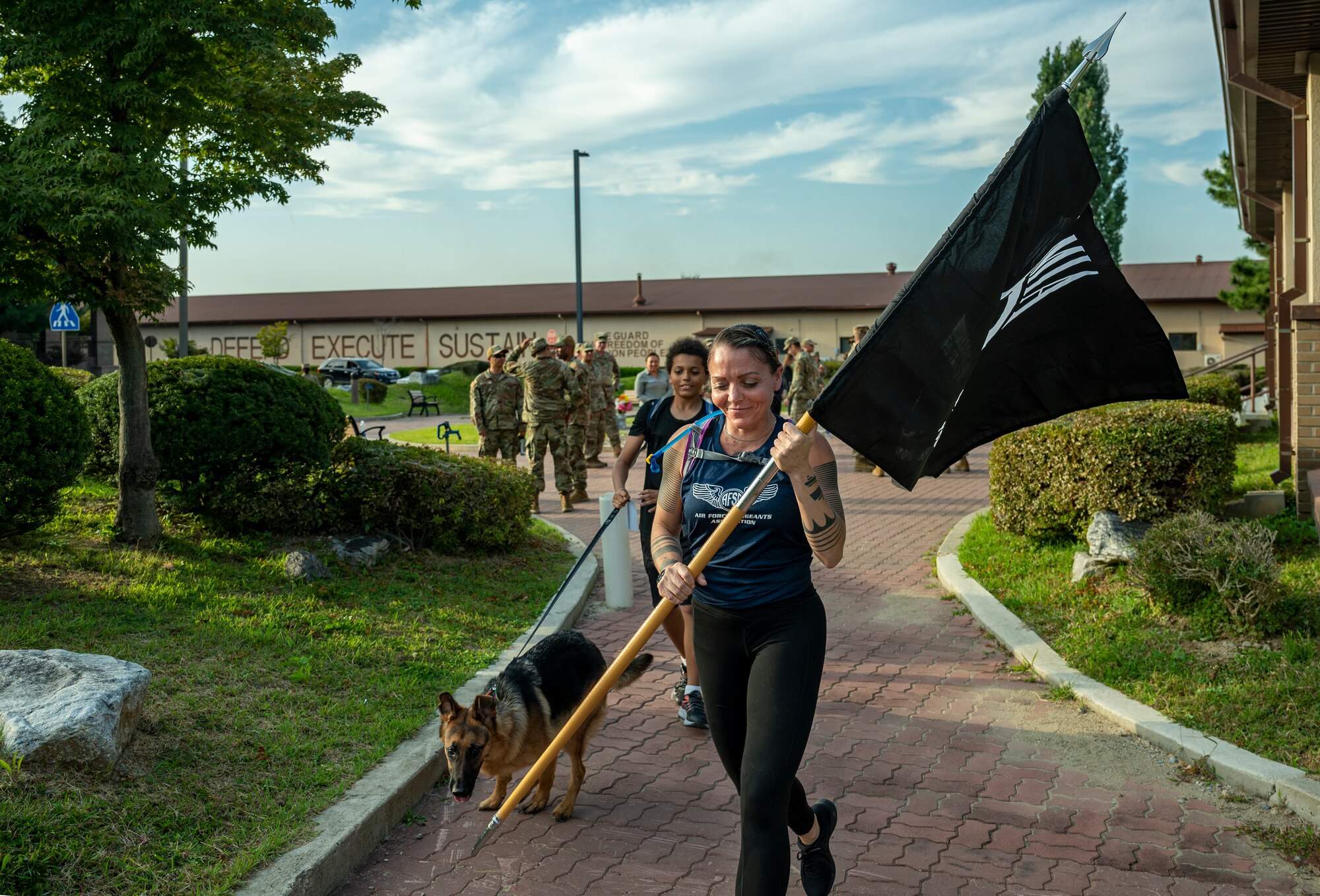 Master Sgt. Armena Gottschalk, 51st Logistics Readiness Squadron material flight superintendent, runs with the prisoner of war and missing in action guidon during POW/MIA week at Osan Air Base, Republic of Korea, Sept. 26, 2022.