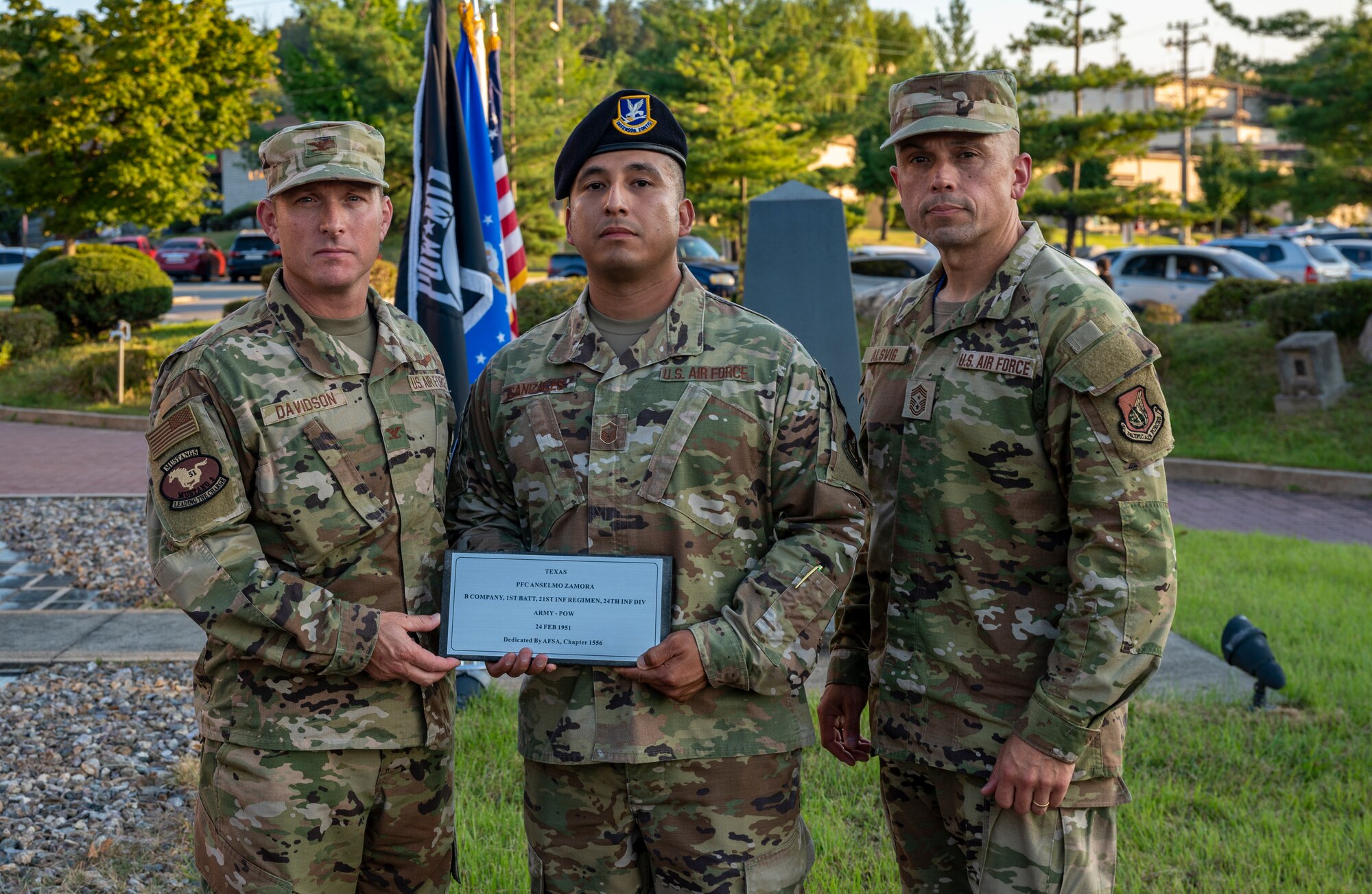Col. Paul Davidson, 51st Fighter Wing vice commander, and Chief Master Sgt. John Alsvig, 51st Fighter Wing command chief, pose for a photo with Master Sgt. Justin Canizales, 51st Security Forces Squadron integrated defense superintendent, during a prisoner of war and missing in action (POW/MIA) remembrance ceremony at Osan Air Base, Republic of Korea, Sept. 27, 2022.