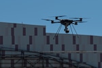 A drone captures imagery from a hangar.