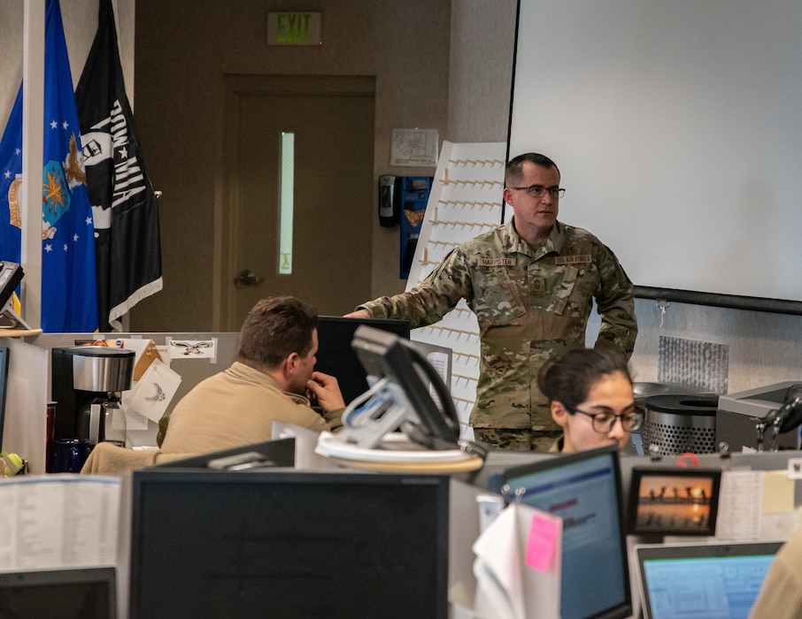 A group of military members stand in a room