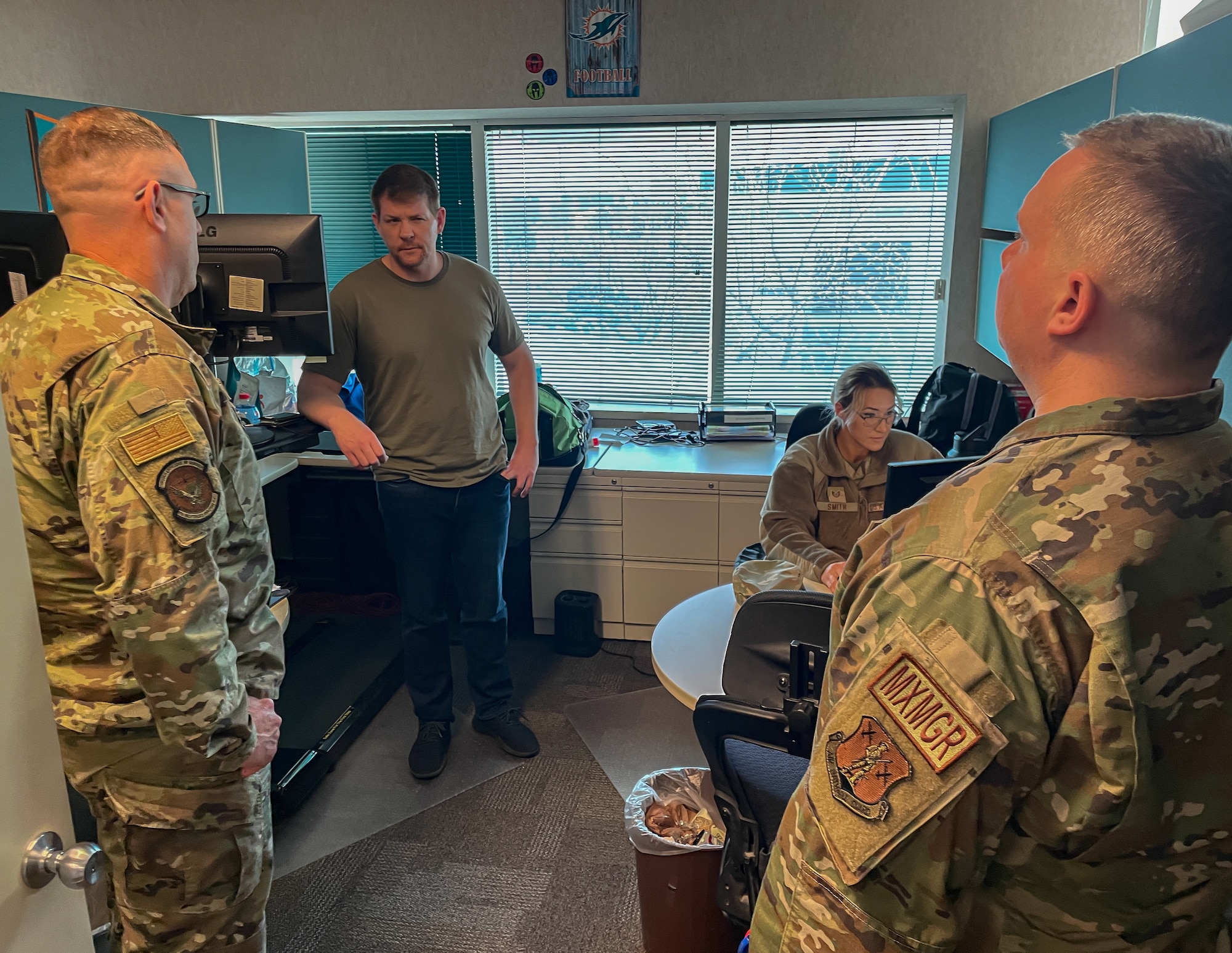 A group of military member have a discussion in a room.