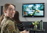 Photo of Airman First Class Emily Sorrell, a member of the 158th Security Forces Squadron, posing for a photograph at the Vermont Air National Guard base in South Burlington, Vermont, March 8, 2023. Sorrell was instrumental in organizing the first Air Force Gaming event for the wing, providing a unique community building experience for Airmen.